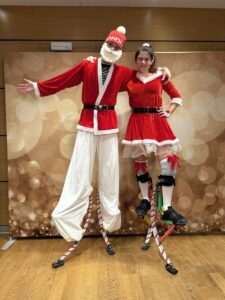 Akrobaté na skákacích botách v kostýmu Santa a paní Santová
